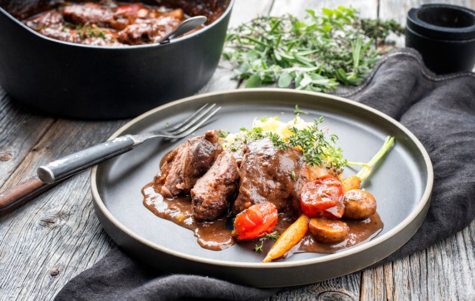 Recept van Varkenswangen gestoofd in donker bier geserveerd op een bord